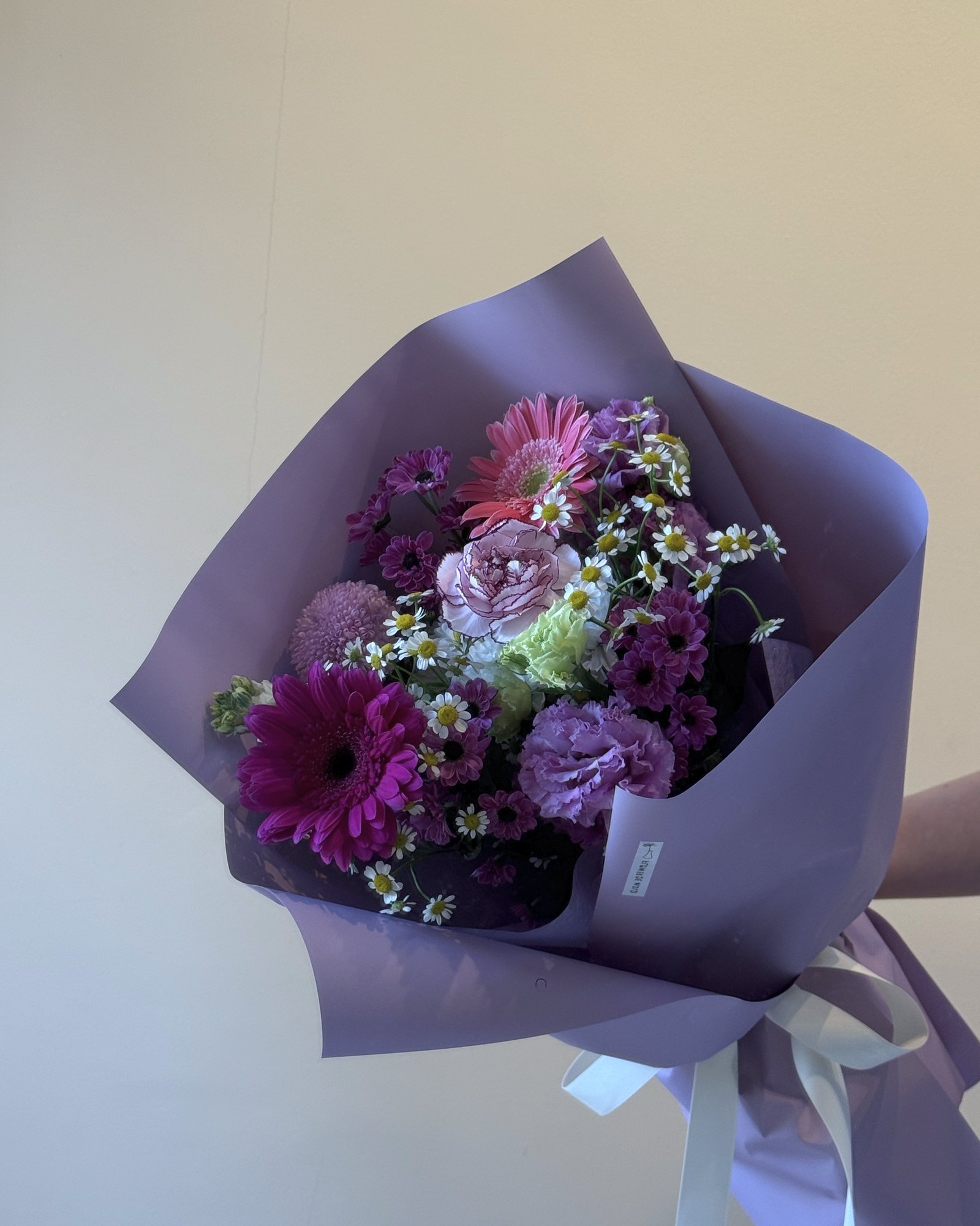 A small posy of pink roses in a cream ceramic bowl