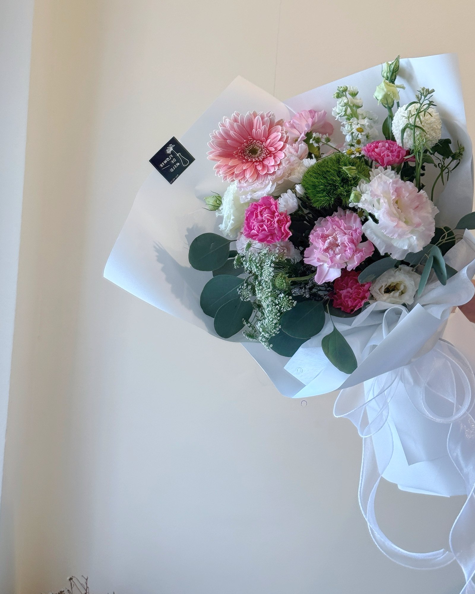 A flower box of loose blush stems with a card